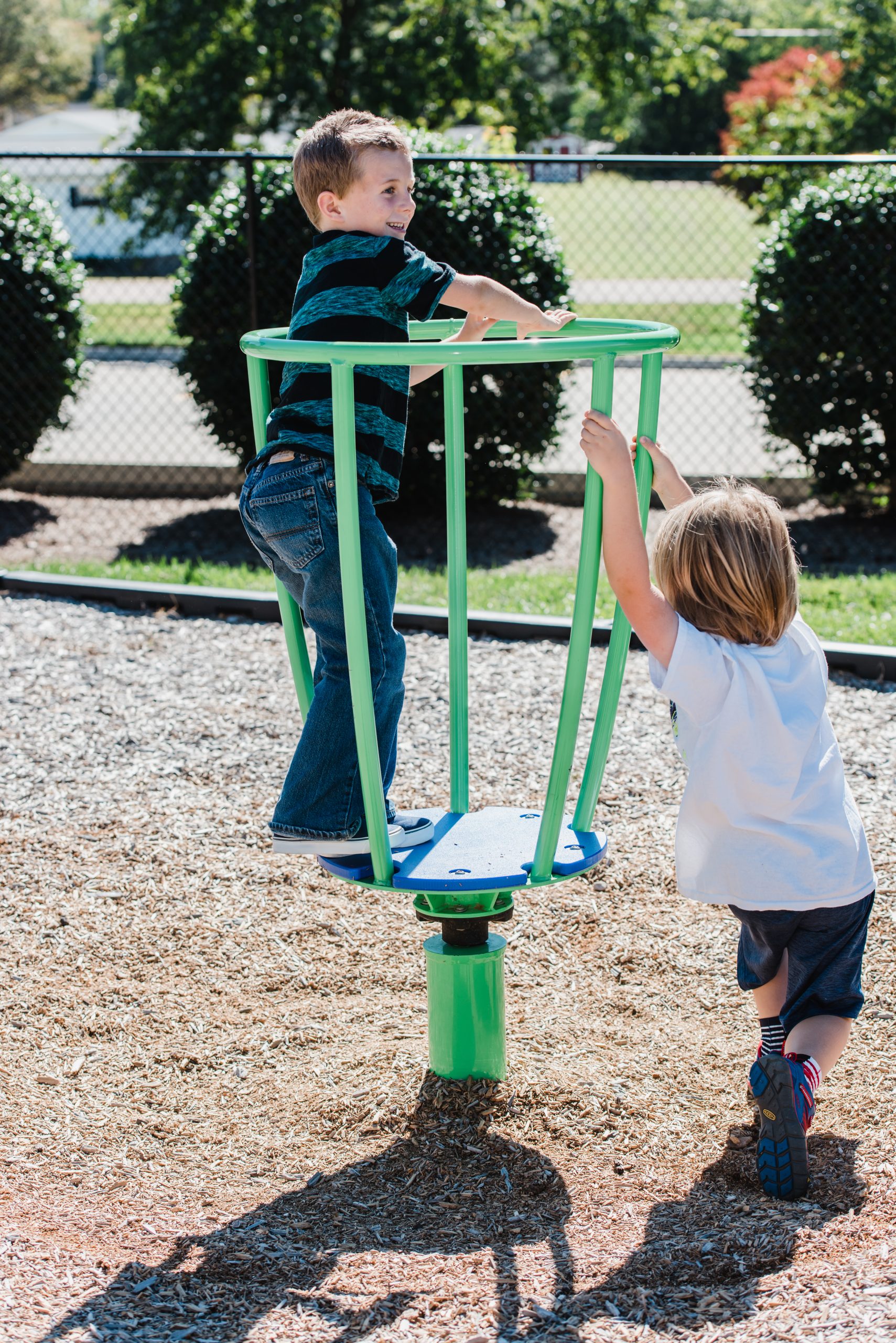 A vibrant multi-colored tea cup spinner on a commercial playground, designed for safe group play.