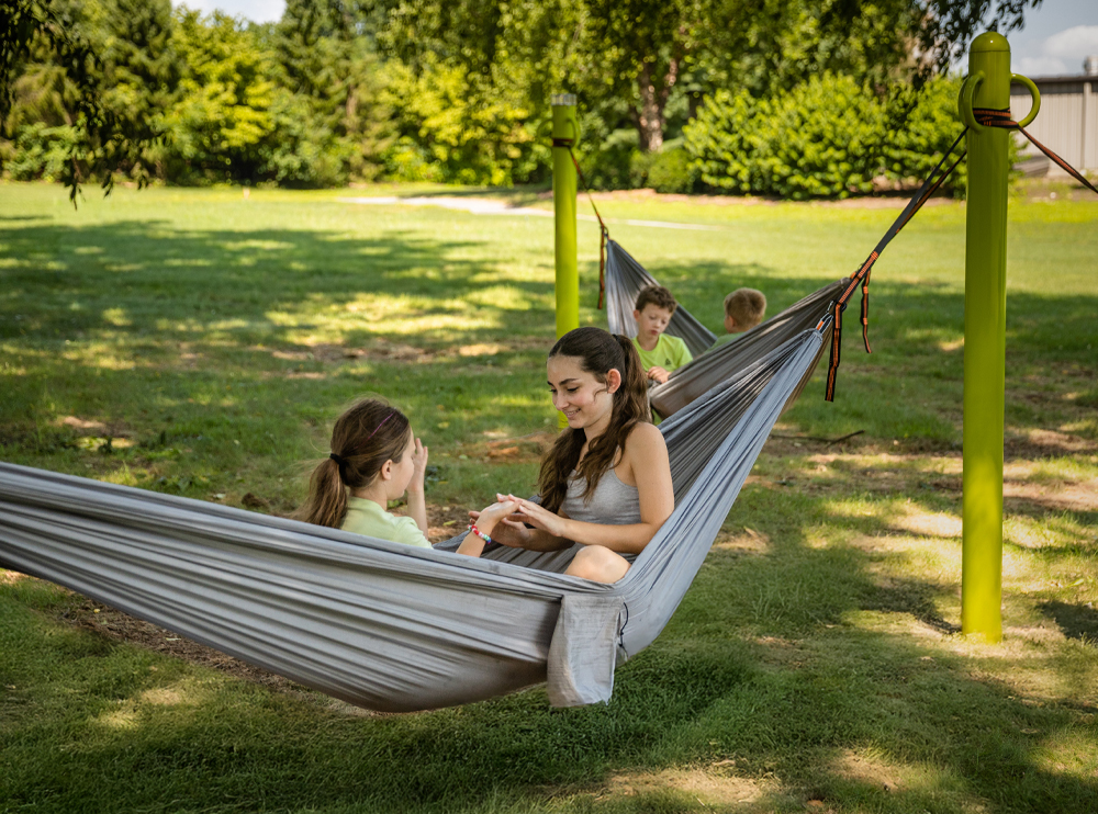 A sturdy metal hammocking post site in a park setting, ready for community use.